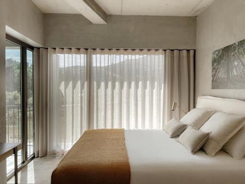 a bedroom with a bed and a large window at Soadro do Zêzere - Hotel Rural e Restaurante in Valhelhas