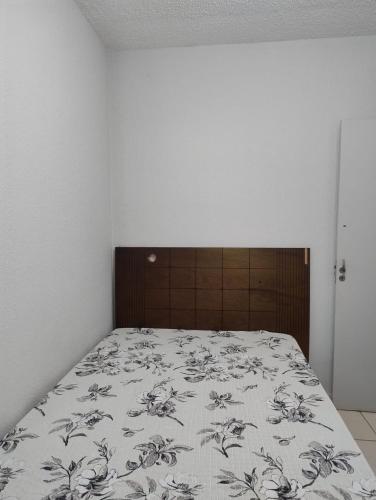 a bedroom with a bed with a floral bedspread at Pedacinho do céu in Dourados