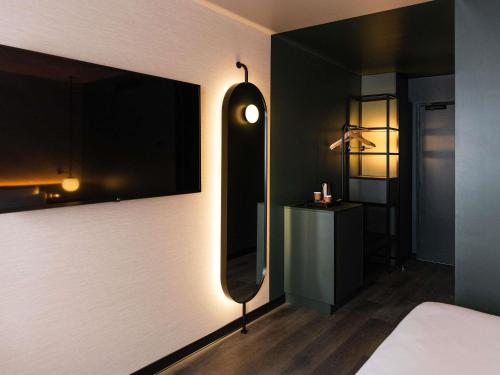 a bedroom with a large mirror and a bed at Novotel Rouen Centre Cathédrale in Rouen