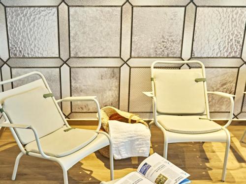 a room with two chairs and a tiled wall at Novotel Rouen Centre Cathédrale in Rouen