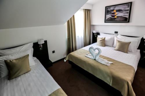 a hotel room with two beds with swans on them at Garni Hotel Zen free parking in Niš
