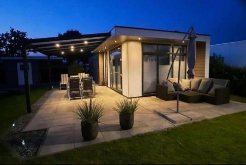 a patio with a couch and a table and chairs at Ferienhaus / Chalet / Bungalow am See, Holland, Niederlande, Lathum in Lathum
