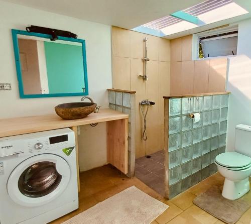 Un baño con lavadora y un inodoro. en Blue lagoon - private access to blue lagoon, en Punaauia