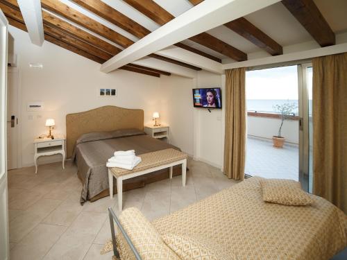 サンタ・テレーザ・ディ・リーヴァにあるMarina di Savocaのベッドルーム1室(ベッド1台付)、リビングルームが備わります。