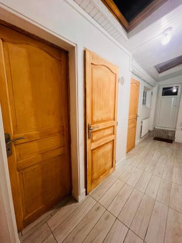 an empty room with two wooden doors and wooden floors at L amienoise in Longueau