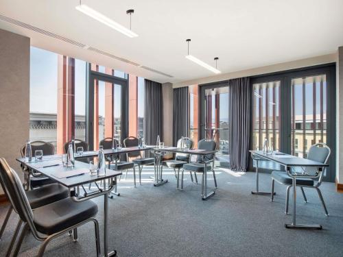a conference room with tables and chairs and windows at Tbilisi Philharmonic Hotel by Mercure in Tbilisi City