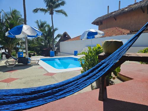 a hammock in front of a house with a pool at Zihua 6bed 3bath Home for 12 with Direct Access to Beach in Zihuatanejo