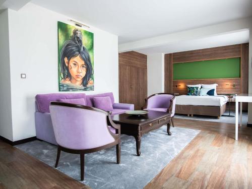 a hotel room with a purple couch and a bed at Ibis Styles Cayenne Centre Amazonia in Cayenne