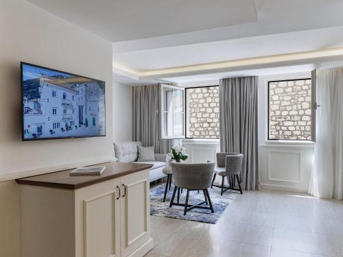 a kitchen and living room with a table and chairs at Heritage Grand Perast By Rixos in Perast
