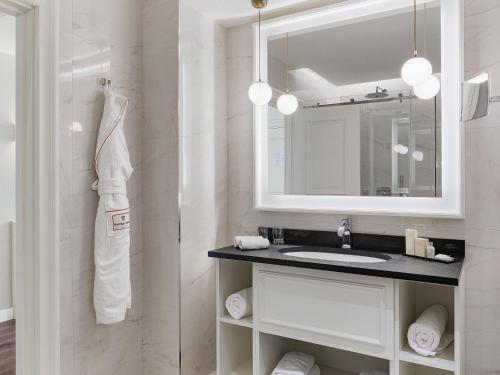 a white bathroom with a sink and a mirror at Heritage Grand Perast By Rixos in Perast