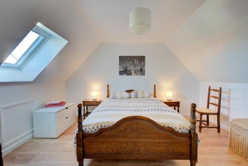 a bedroom with a wooden bed in a attic at La Maison à Côté - 6 couchages in Monnaie
