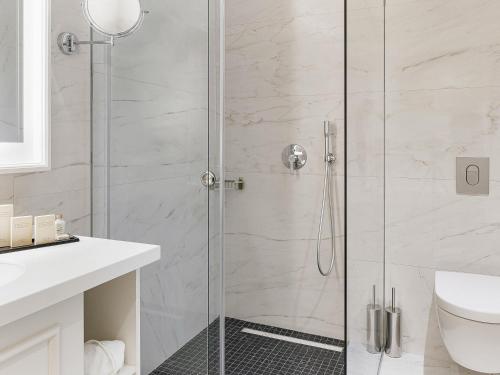 a shower with a glass door in a bathroom at Heritage Grand Perast By Rixos in Perast