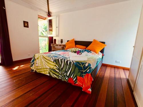 Un dormitorio con una cama con un edredón colorido. en Blue lagoon - private access to blue lagoon, en Punaauia