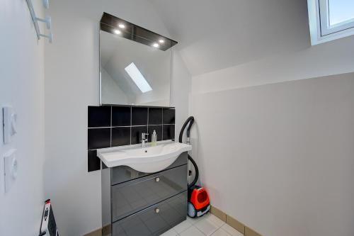 a bathroom with a sink and a mirror at La Maison à Côté - 6 couchages in Monnaie