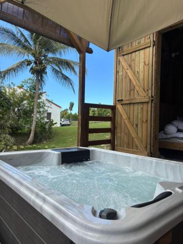 a jacuzzi tub in front of a tent at La pause verte bungalow in Sainte-Anne