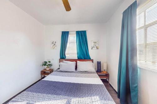a bedroom with a large bed with blue curtains at Cozy 1br Casita in Southwest w Wifi! in Albuquerque