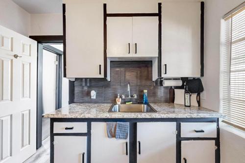a kitchen with white cabinets and a sink at Cozy 1br Casita in Southwest w Wifi! in Albuquerque