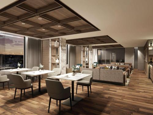 a restaurant with tables and chairs and a couch at Mövenpick Hotel Jakarta City Centre in Jakarta