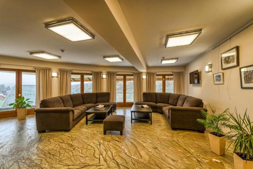 a large living room with couches and tables and windows at Hotel Pod Wulkanem in Kluszkowce