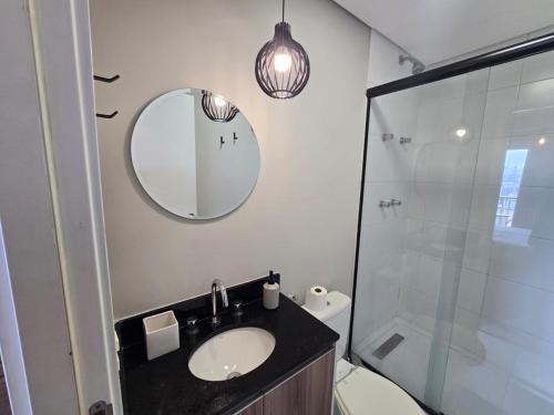 a bathroom with a sink and a mirror and a toilet at Conforto no Largo do Arouche 77 c Varanda, Lazer e Vista A 250m do Metrô in São Paulo