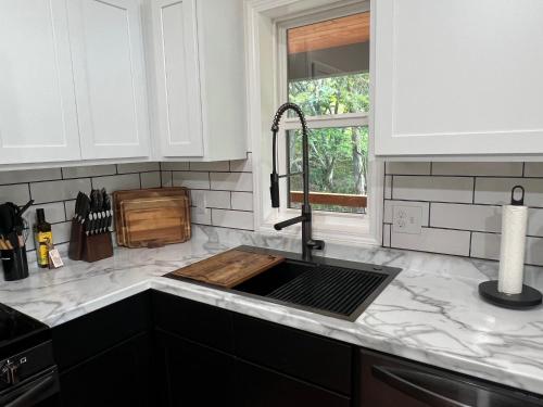 Ruth's Place Tiny Home Retreat 1 mile to town في Burnsville: طاولة مطبخ مع حوض ونافذة