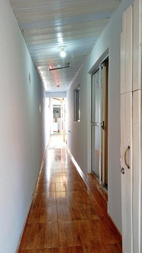 an empty hallway with a wooden floor in a house at Refúgio Central in Chapada dos Guimarães