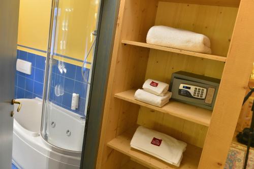 bagno con lavandino, doccia e asciugamani di Hotel Astra a Livigno