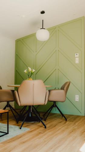 a table and chairs in a room with a green wall at Natursee-Chalet, Angeln, Wellness, Spa, Ponyhof in Twist