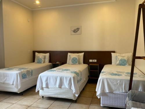 Ένα ή περισσότερα κρεβάτια σε δωμάτιο στο Caramelo hospedaria, localização privilegiada com conforto e privacidade