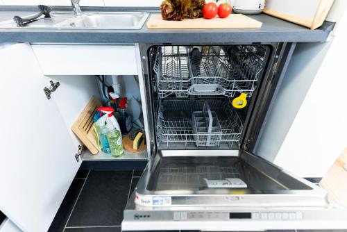 an empty dishwasher in a kitchen next to a sink at BellaBene modernes Studioapartment in zentraler Lage, Arbeitsplatz, Parkplatz in Pforzheim