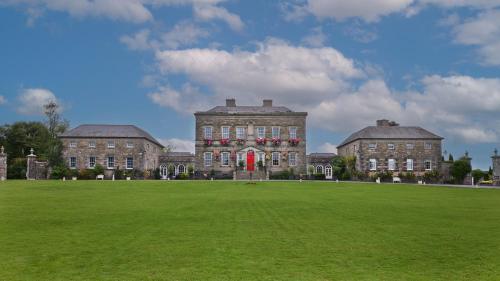 a large building with a grass field in front of it at Bellinter House Hotel & Spa in Navan