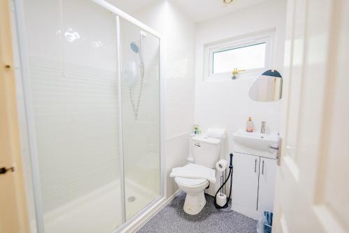カーディフにある6 Beds House with Free Parking, Garden & Fast WiFiのシャワーとトイレ付きの白いバスルーム