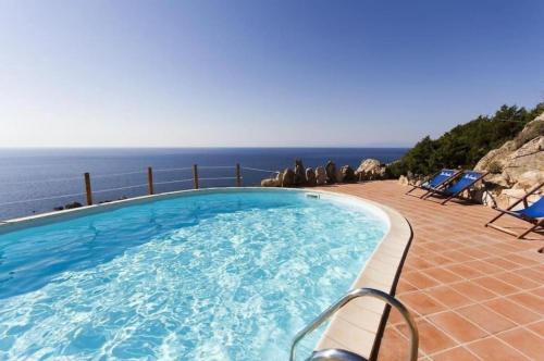 a swimming pool with a view of the ocean at Villa La Dolce Vista & Jacuzzi in Costa Paradiso