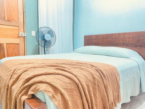 a bedroom with a bed with an orange blanket and a fan at Rous place# 2 in Fortuna