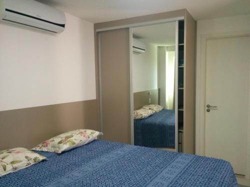 1 dormitorio con 2 camas y espejo en Açai Flat, en Natal