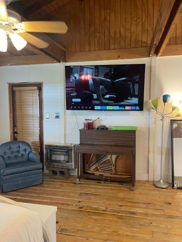 a living room with a large flat screen tv on the wall at Downtown Lafayette Gem-Stylish 1BR Apartment in Lafayette