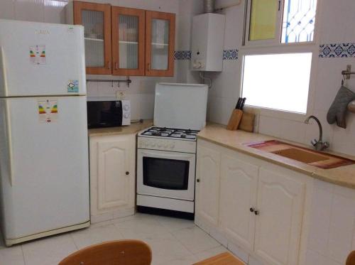 a kitchen with a white stove and a refrigerator at Maison Myriam in Nabeul