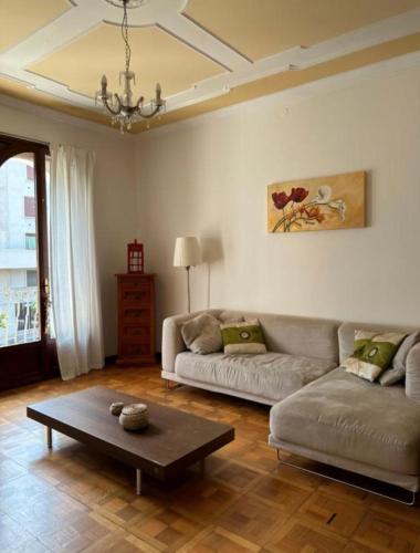 Una sala de estar con un sofá y una mesa de café. en Marcella Grand Apartment, en Verona