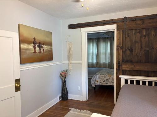 a bedroom with a bed and a painting on the wall at The Crescent House in Hutchinson