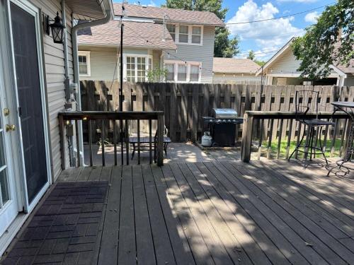 a wooden deck with a table and chairs on a house at The Crescent House in Hutchinson