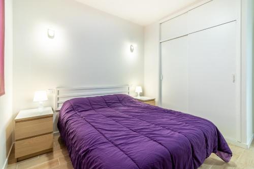a bedroom with a purple bed and two night stands at Guaires 217 in Mogán