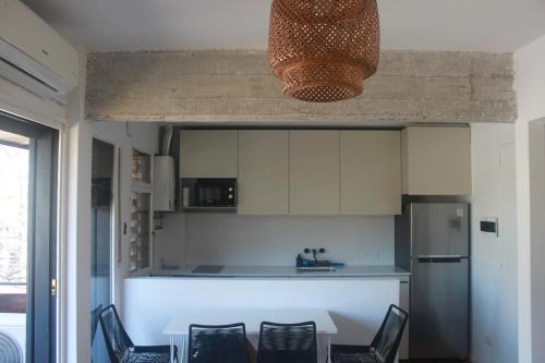 Una cocina con mesa y sillas y un refrigerador. en Acassuso Style, en Acassuso