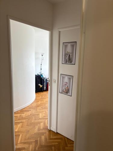 an open door to a hallway with two pictures on the wall at Appart Edmonds in Nanterre
