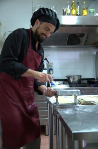 a man standing in a kitchen preparing food at Hotel Florence in Manerba del Garda