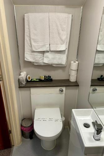 a small bathroom with a white toilet and towels at The Kings Head Inn in Gloucester