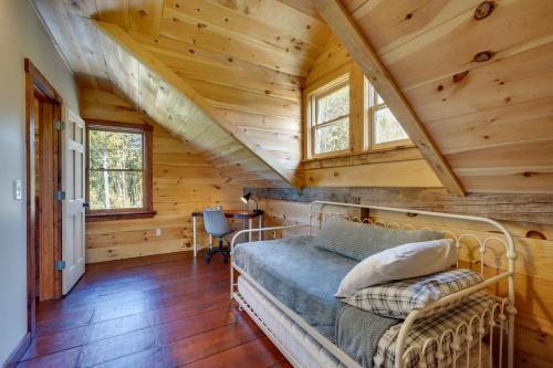 a bedroom in a log cabin with a bed and windows at Unplug, Unwind and Explore Remote Vermont Cabin in Sharon