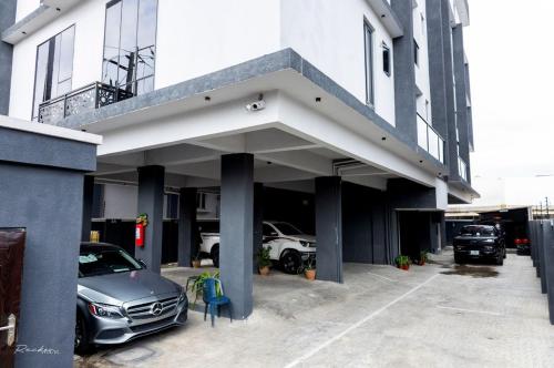 Un coche aparcado en un aparcamiento junto a un edificio. en Smart one bedroom apartments with massage chair and ps5 Ikoyi, en Lagos