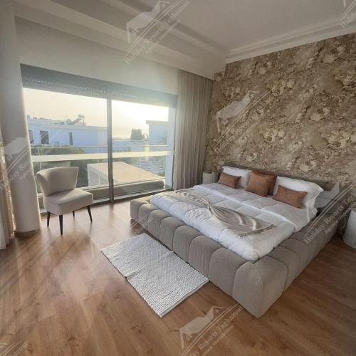 a bedroom with a large bed with a stone wall at Almost Heaven Heated Pool Villa Taghazout Bay Amda in Taghazout