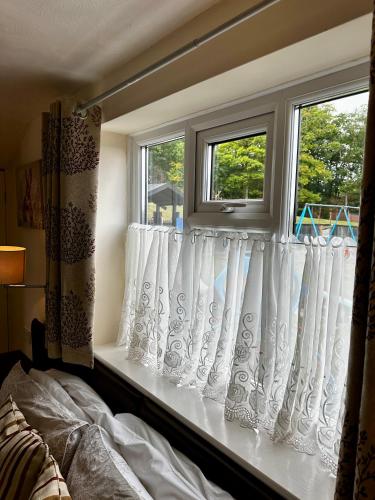 a window with white curtains in a bedroom at The Kings Head Inn in Gloucester