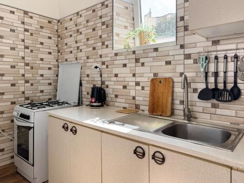 a kitchen with a sink and a stove at Простора 2-кімн квартира в центрі Чернівців на Турецькій 18 in Chernivtsi